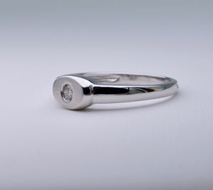 18K white gold ring with one small diamond set in an oval surface