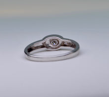 18K white gold ring with one small diamond set in an oval surface