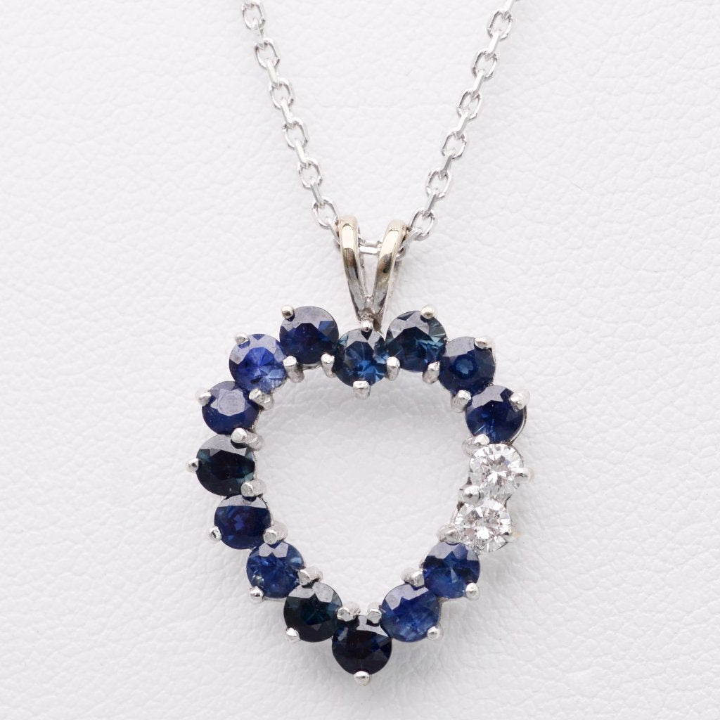 14K white gold heart-shaped pendant with fourteen Sapphires and two Diamonds