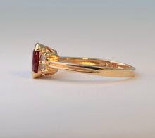 14K yellow gold ring with one center oval Ruby and four side Diamonds